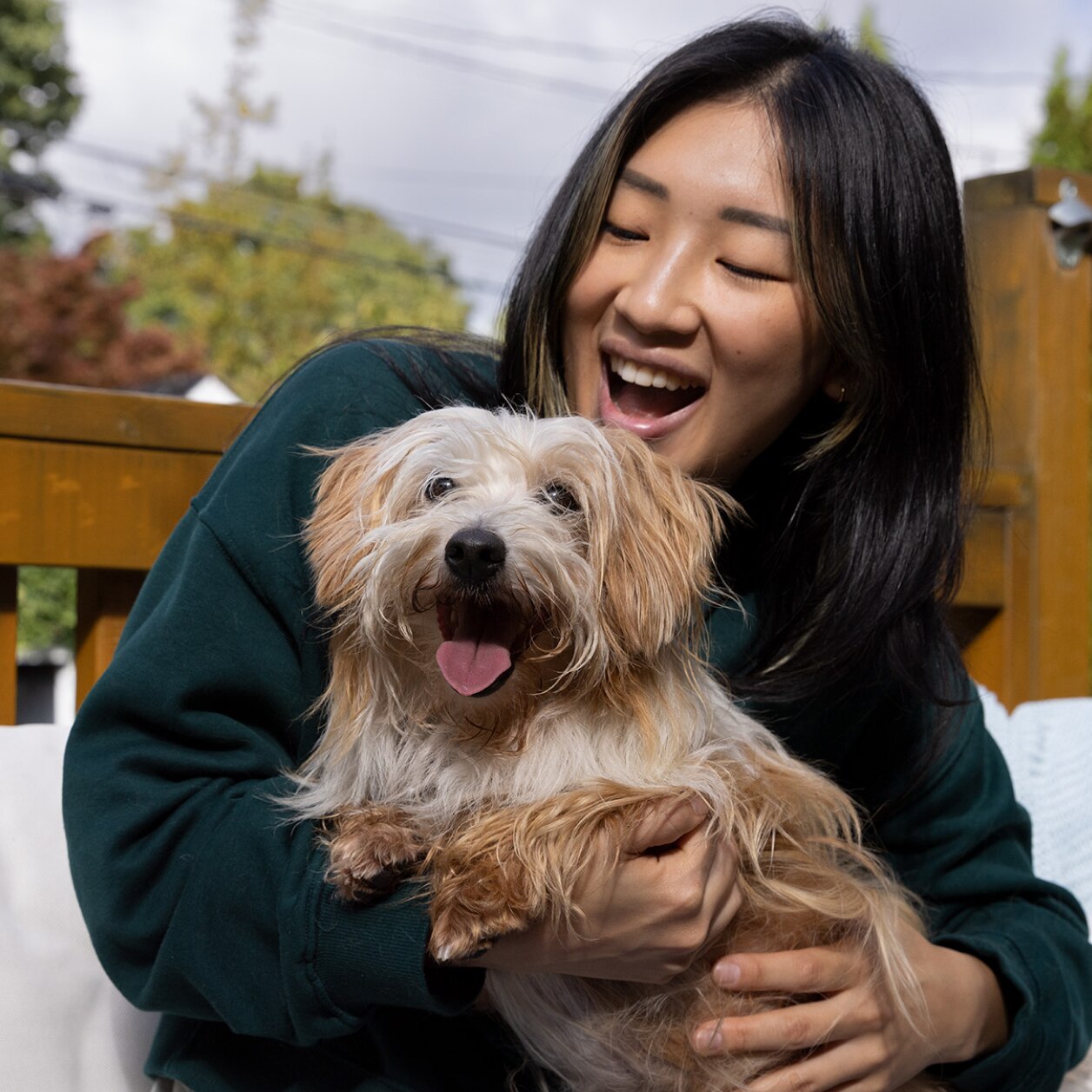 A woman with a happy small dog in her arms