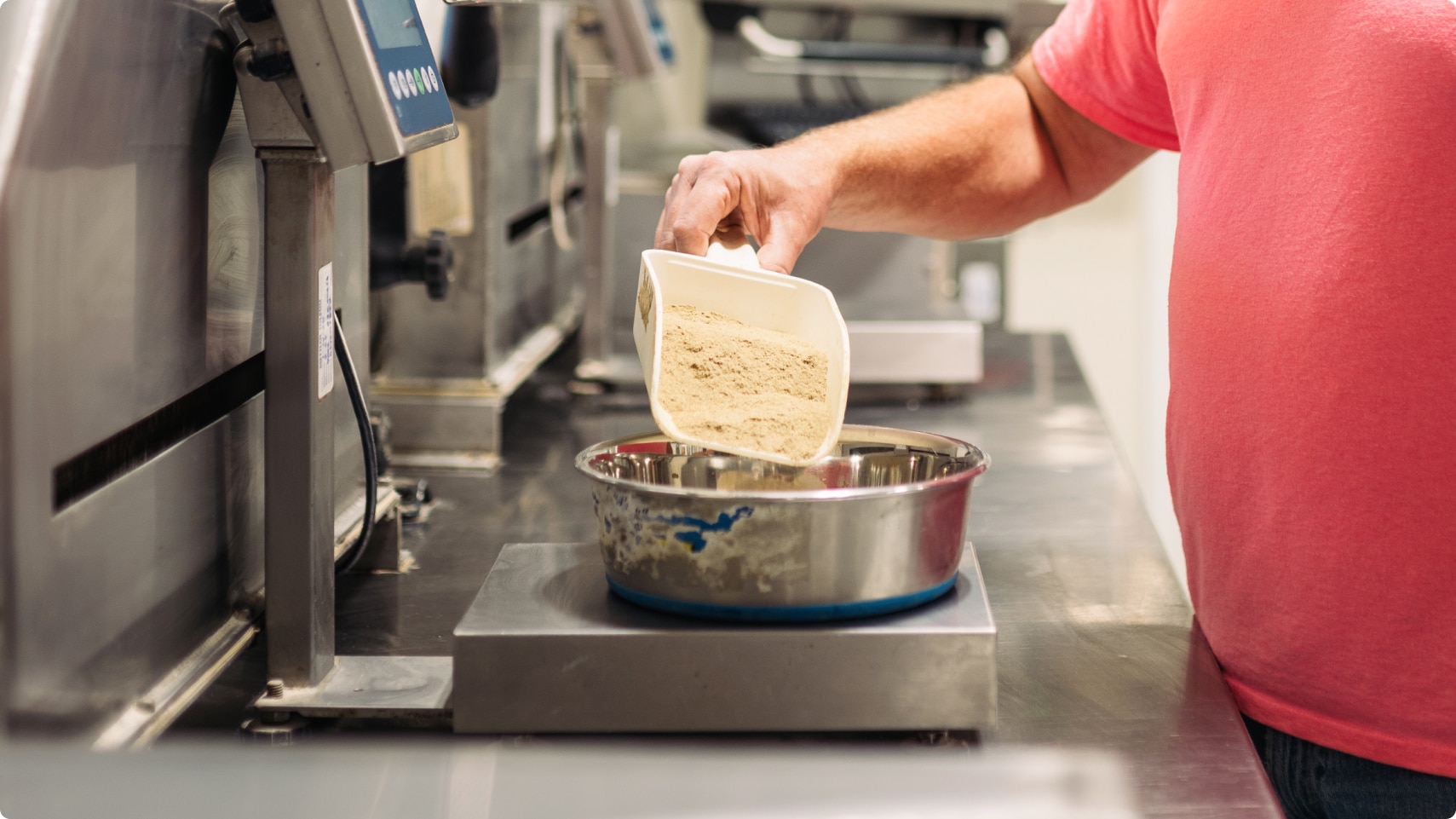 Un angajat Hill's măsoară ingredientele pe un cântar